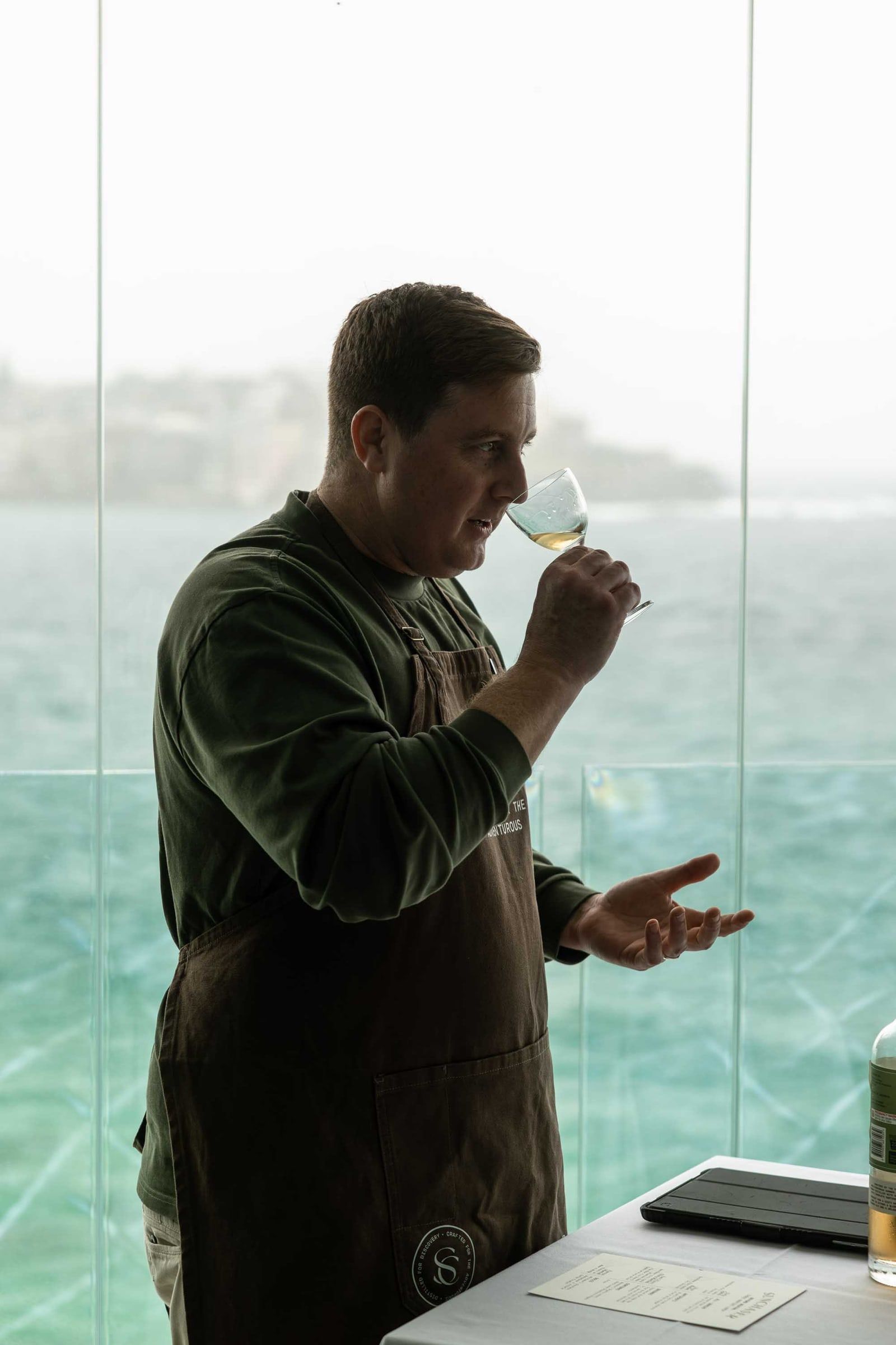 A Sunchaser founder nosing a glass of vodka by the harbour.