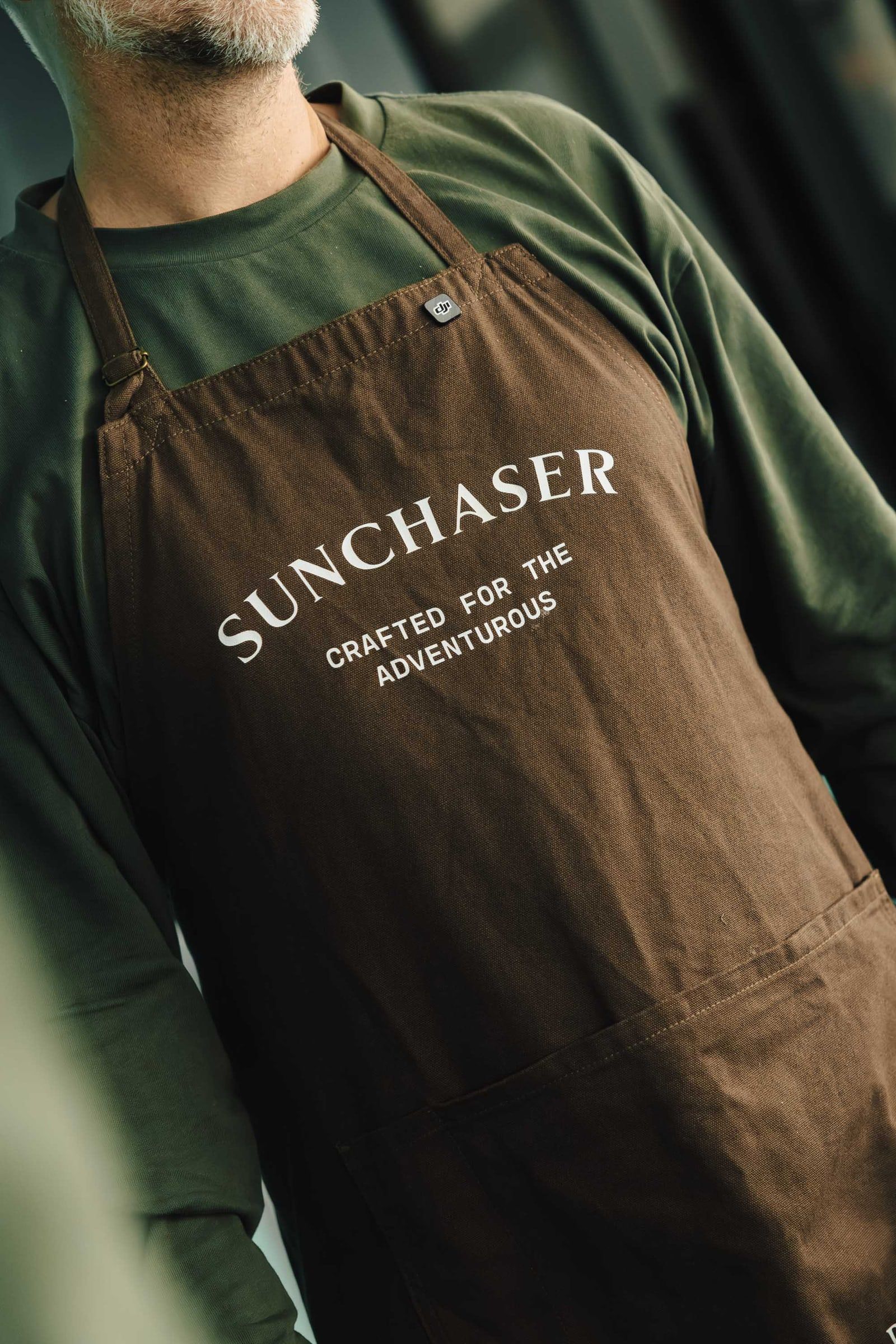 A bartender wearing a Sunchaser apron embroidered with “Crafted for the adventurous”.
