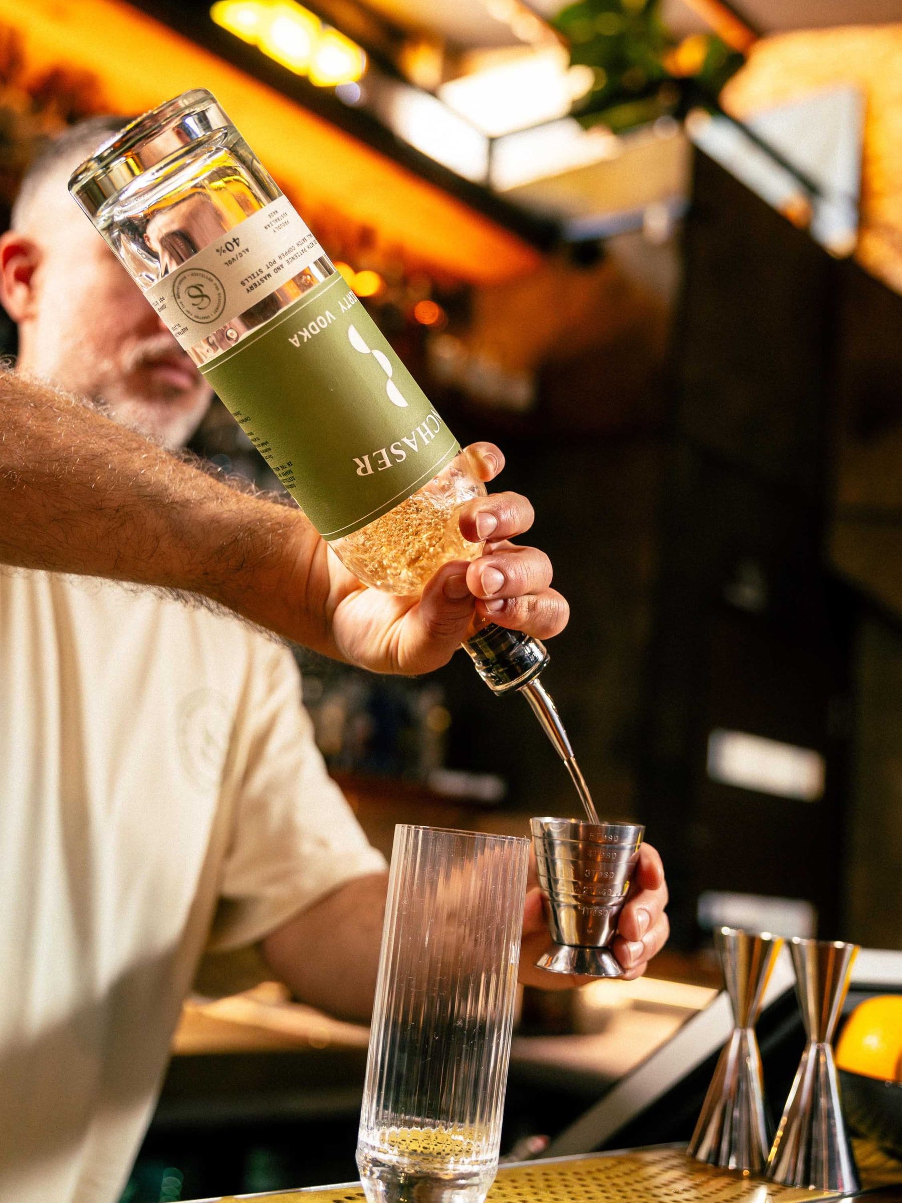 A bartender pours Sunchaser Dirty Vodka into a jigger.