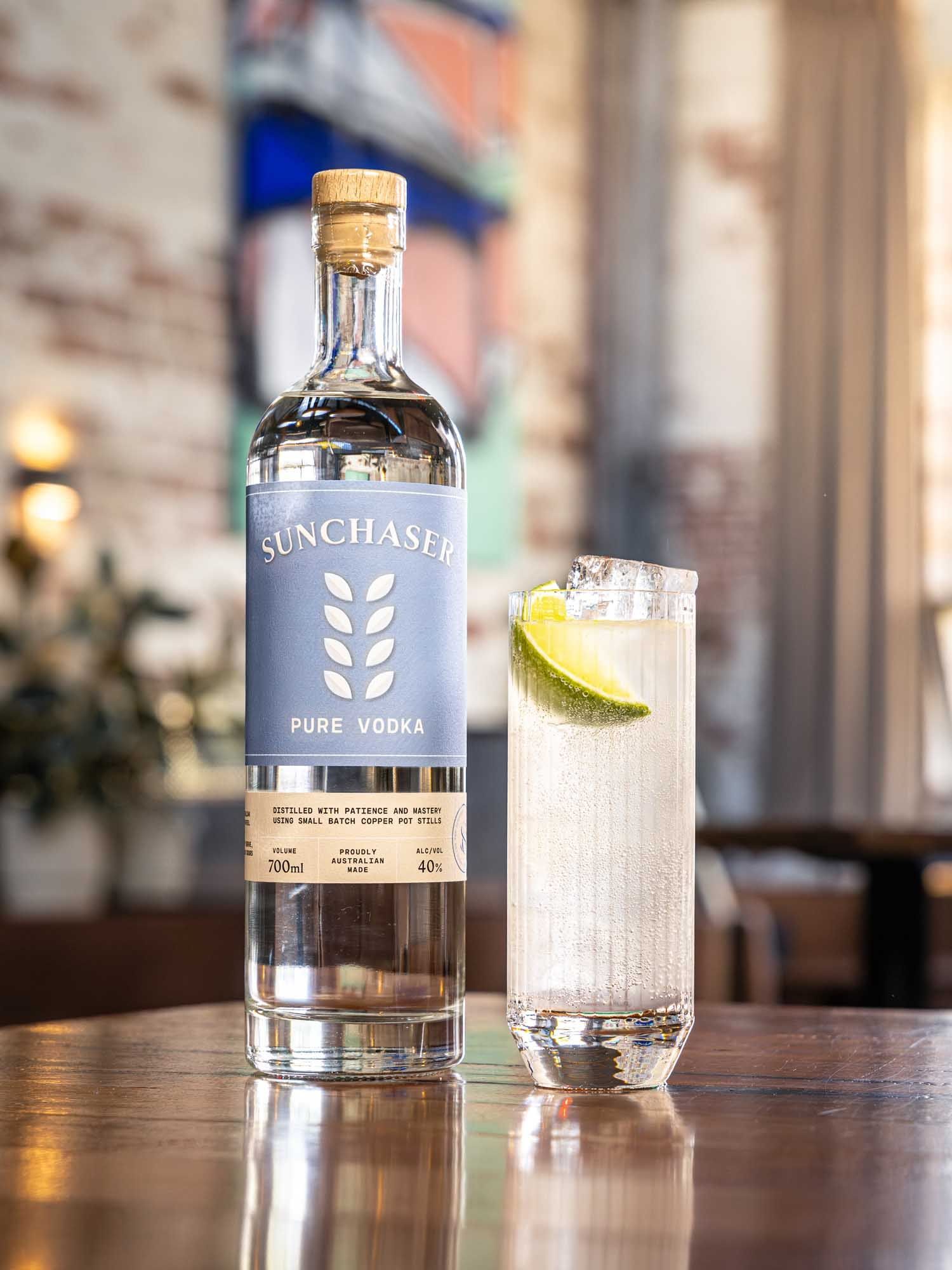 A Yuzu Ricky highball beside a bottle of Sunchaser Pure Vodka.